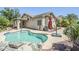 A backyard featuring a private pool, rock features, desert landscaping, and an umbrella with stand at 16186 W Port Royale Ln, Surprise, AZ 85379