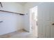 An empty walk-in closet with built-in shelving next to a bathroom at 16186 W Port Royale Ln, Surprise, AZ 85379