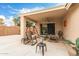 Relaxing covered back patio with a ceiling fan, comfortable rocking chairs, and outdoor decor at 16526 W Desert Ln, Surprise, AZ 85388