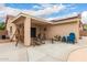 Covered back patio with comfortable seating, a ceiling fan, and a wooden porch swing at 16526 W Desert Ln, Surprise, AZ 85388