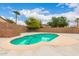 Private backyard featuring a refreshing pool, palm trees and an elegant brick wall, perfect for outdoor entertaining at 16526 W Desert Ln, Surprise, AZ 85388