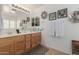 Well-lit bathroom features a double vanity with a large mirror and decorative wall art at 16526 W Desert Ln, Surprise, AZ 85388