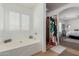 Bright bathroom boasts a soaking tub next to a window and a decorative shower curtain at 16526 W Desert Ln, Surprise, AZ 85388