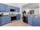 Stylish kitchen with stainless steel appliances, blue cabinets, and ample counter space at 16526 W Desert Ln, Surprise, AZ 85388