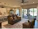 Open-concept living room with a ceiling fan, modern furniture, and seamless indoor/outdoor flow to the covered patio at 16822 W Catalina Dr, Goodyear, AZ 85395