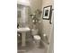 Elegant powder room featuring a pedestal sink, decorative mirror, and stylish wall art at 16822 W Catalina Dr, Goodyear, AZ 85395