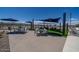 Outdoor community area with tables, chairs, umbrellas, and lounge chairs against a backdrop of blue skies at 17831 W Pasadena Ave, Litchfield Park, AZ 85340