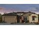 Charming single-story home with a two-car garage and stone accents around the window and doorway at 17836 W Pasadena Ave, Litchfield Park, AZ 85340