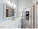 Bathroom featuring marble countertops, modern vanity, decorative mirror and access to the closet at 1904 E Grand Canyon Dr, Chandler, AZ 85249