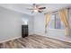 Neutral bedroom with wood-look floors, a ceiling fan, window, and accent lighting, offering a serene retreat at 1904 E Grand Canyon Dr, Chandler, AZ 85249