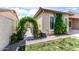 Exterior side view of home featuring an archway with vines, lush green lawn, and desert landscaping at 1904 E Grand Canyon Dr, Chandler, AZ 85249