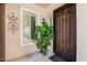 Ornate wood front door with iron scrollwork, sidelight windows, and a potted plant add elegance to the entry at 1904 E Grand Canyon Dr, Chandler, AZ 85249