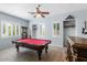 Bright game room featuring a red billiard table, wood-look tile flooring, and window shutters at 1904 E Grand Canyon Dr, Chandler, AZ 85249