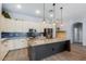 Modern kitchen features white cabinets, a granite-topped island, stainless steel appliances, and backsplash at 1904 E Grand Canyon Dr, Chandler, AZ 85249