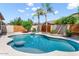 Backyard pool featuring a raised hot tub and water feature, surrounded by desert landscaping and a wood fence at 1904 E Grand Canyon Dr, Chandler, AZ 85249