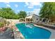 Lush backyard with a sparkling pool, mature trees, and a covered patio area at 1924 S Rome St, Gilbert, AZ 85295