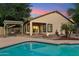 Beautiful pool area with a covered patio, firepit, and mature desert landscaping at 1924 S Rome St, Gilbert, AZ 85295