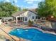 Spacious backyard with a pool, covered patio, and mature trees at 1924 S Rome St, Gilbert, AZ 85295