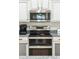 Modern kitchen with stainless steel appliances, granite countertops, and white cabinets with contrasting trim at 1924 S Rome St, Gilbert, AZ 85295