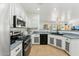 Bright kitchen with white cabinets, stainless steel appliances, and a breakfast bar with granite countertops at 1924 S Rome St, Gilbert, AZ 85295