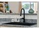 Stylish kitchen sink with a sleek black faucet and granite countertop with a decorative design at 1924 S Rome St, Gilbert, AZ 85295