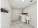 Practical laundry room with washer, dryer, utility sink, and tile floors with neutral paint at 20149 N 92Nd Ave, Peoria, AZ 85382