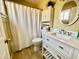 Bright bathroom with a white vanity, round mirror, and shower with white textured curtain at 2537 E Hazelwood St, Phoenix, AZ 85016