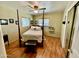 Bedroom with hardwood floors, a ceiling fan, and a four-poster bed with bench seating at 2537 E Hazelwood St, Phoenix, AZ 85016