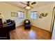 Bedroom with hardwood floors, a ceiling fan, desk, and chair under two windows at 2537 E Hazelwood St, Phoenix, AZ 85016