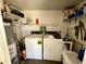 Practical laundry room with washer, dryer, shelving, and water heater for added convenience at 2537 E Hazelwood St, Phoenix, AZ 85016