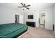 Neutral bedroom with carpet flooring, ceiling fan and a tv with closet and bathroom entrance at 25951 W Piute Ave, Buckeye, AZ 85396