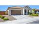 Exterior view of a one story home with a tile roof, desert landscaping and an attached garage at 25951 W Piute Ave, Buckeye, AZ 85396
