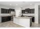 Well-lit kitchen featuring dark cabinets, stainless steel appliances, and a granite countertop island at 25951 W Piute Ave, Buckeye, AZ 85396