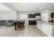 Open kitchen with dark cabinets, stainless steel appliances, and an island open to the living area at 25951 W Piute Ave, Buckeye, AZ 85396