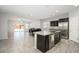 Open kitchen features dark cabinets, granite countertops, and an island with views of the dining area at 25951 W Piute Ave, Buckeye, AZ 85396