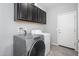 Modern laundry room with updated appliances and ample cabinet space for storage at 25951 W Piute Ave, Buckeye, AZ 85396