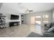 Open-concept living room with a ceiling fan, large television and sliding doors leading to the backyard at 25951 W Piute Ave, Buckeye, AZ 85396
