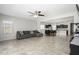 Open living space featuring a sofa and dining area, next to the kitchen with dark cabinets at 25951 W Piute Ave, Buckeye, AZ 85396