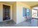 Charming front porch with a decorative door and a sitting chair at 25951 W Piute Ave, Buckeye, AZ 85396