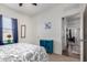 Airy bedroom showcasing ceiling fan, natural light, and stylish blue accents with decorative patterned bedding at 30388 N Opal Dr, San Tan Valley, AZ 85143