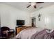 Bedroom featuring ceiling fan, adjacent room view, wooden bed frame, and a cozy purple chair at 30388 N Opal Dr, San Tan Valley, AZ 85143
