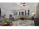 Comfortable living room featuring a gray sectional sofa, ceiling fan and decorative rug at 30388 N Opal Dr, San Tan Valley, AZ 85143
