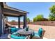 Inviting covered patio with outdoor seating and a spacious gravel backyard, perfect for relaxation and entertainment at 30388 N Opal Dr, San Tan Valley, AZ 85143