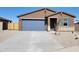 Charming single-story home featuring a spacious driveway and blue accent garage door and shuttered window at 311 S San Gregorio Ln, Casa Grande, AZ 85194