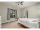 Simple bedroom with plush carpet, large window, and ceiling fan at 3331 N Acacia Way, Buckeye, AZ 85396