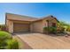 A long, brick driveway leads to a two-car garage attached to a single-Gathering home at 3331 N Acacia Way, Buckeye, AZ 85396