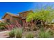 A charming single-Gathering home features desert landscaping, a stone facade, and mature desert trees at 3331 N Acacia Way, Buckeye, AZ 85396