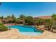 Backyard pool with lush landscaping and rock waterfall feature at 3331 N Acacia Way, Buckeye, AZ 85396