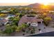 An elevated aerial view showing the house situated in a desert landscape with mountain backdrop at sunset at 35556 N 87Th Pl, Scottsdale, AZ 85266