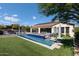 Stunning backyard with a sparkling pool, lush green grass, and outdoor seating areas, perfect for relaxation and entertainment at 35556 N 87Th Pl, Scottsdale, AZ 85266